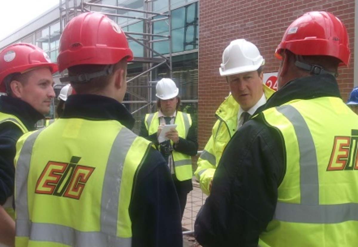Better times: David Cameron on site with EIC meeting apprentices