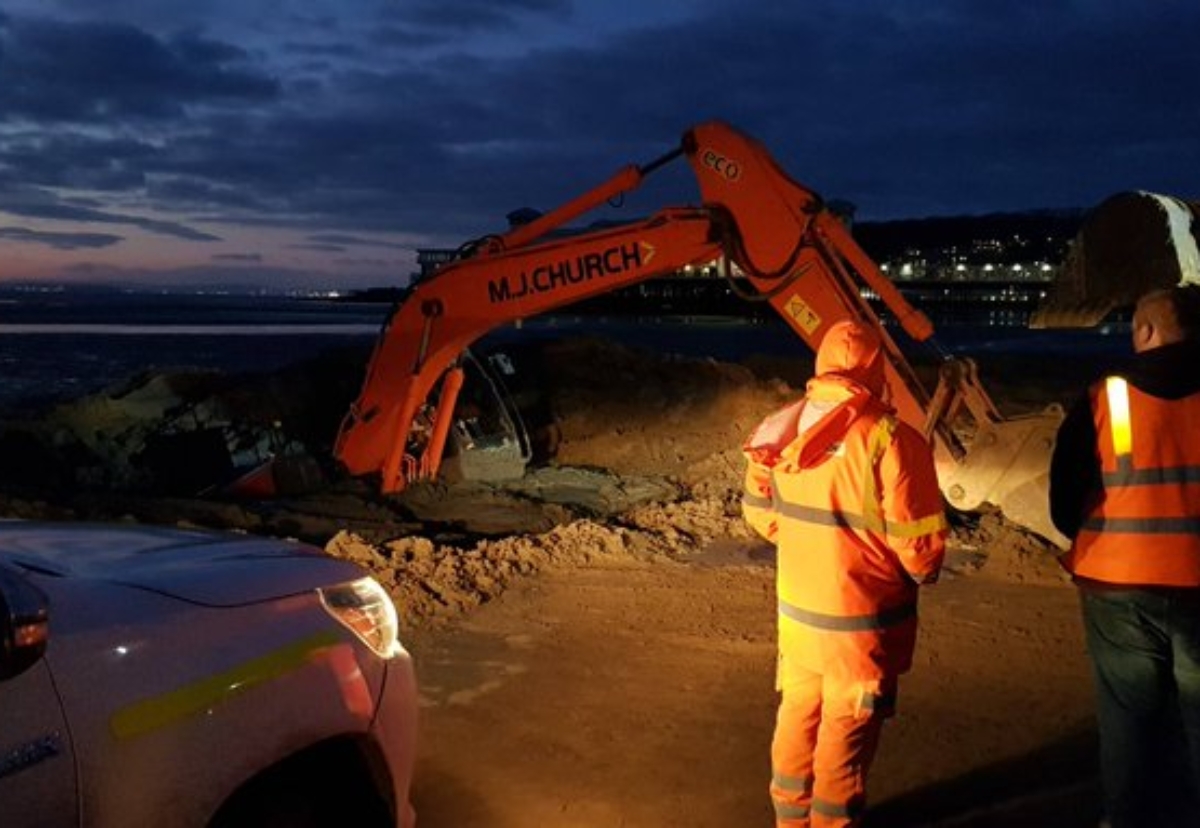 Police photos show the digger stuck fast as the tide came in